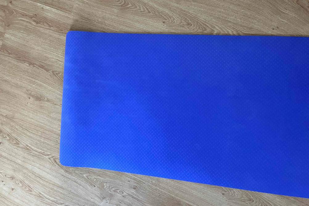 Im Test: Gymnastikmatte in lila liegt ausgerollt auf Holzboden.