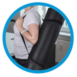 Eine Gymnastikmatte wird zusammengerollt mit einem Gurt über die Schulter getragen.