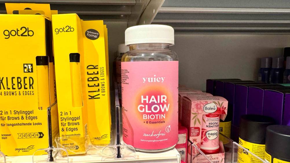 Mehrere Dosen der Haar-Gummibärchen im Test in einem Verkaufsregal neben anderen Produkten.