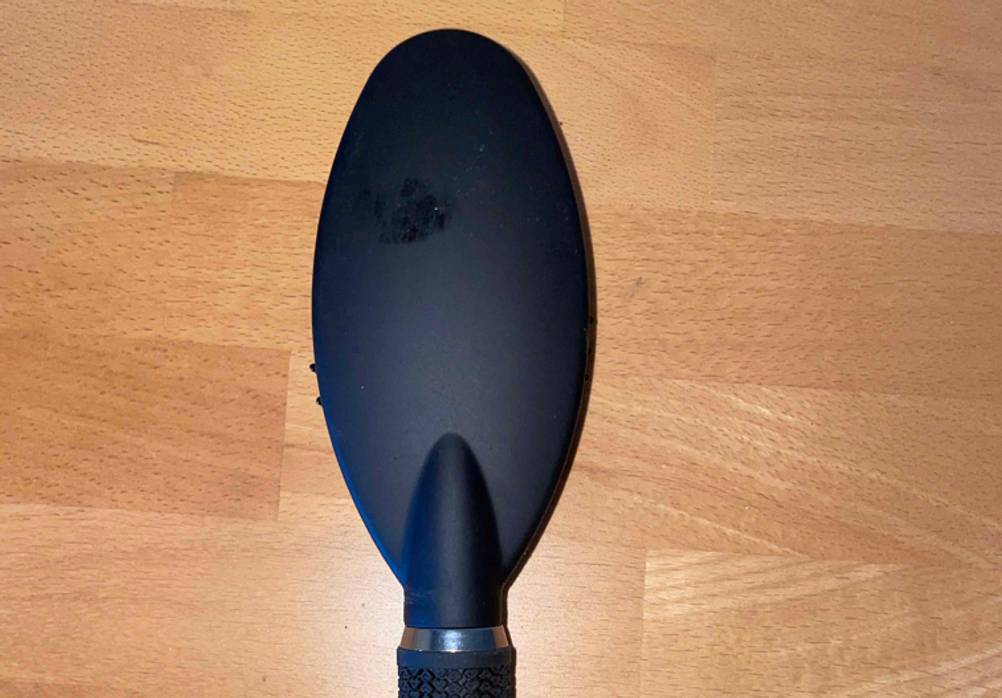 Nahaufnahme der Rückseite der getesteten Haarbürste auf einer Holzfläche.