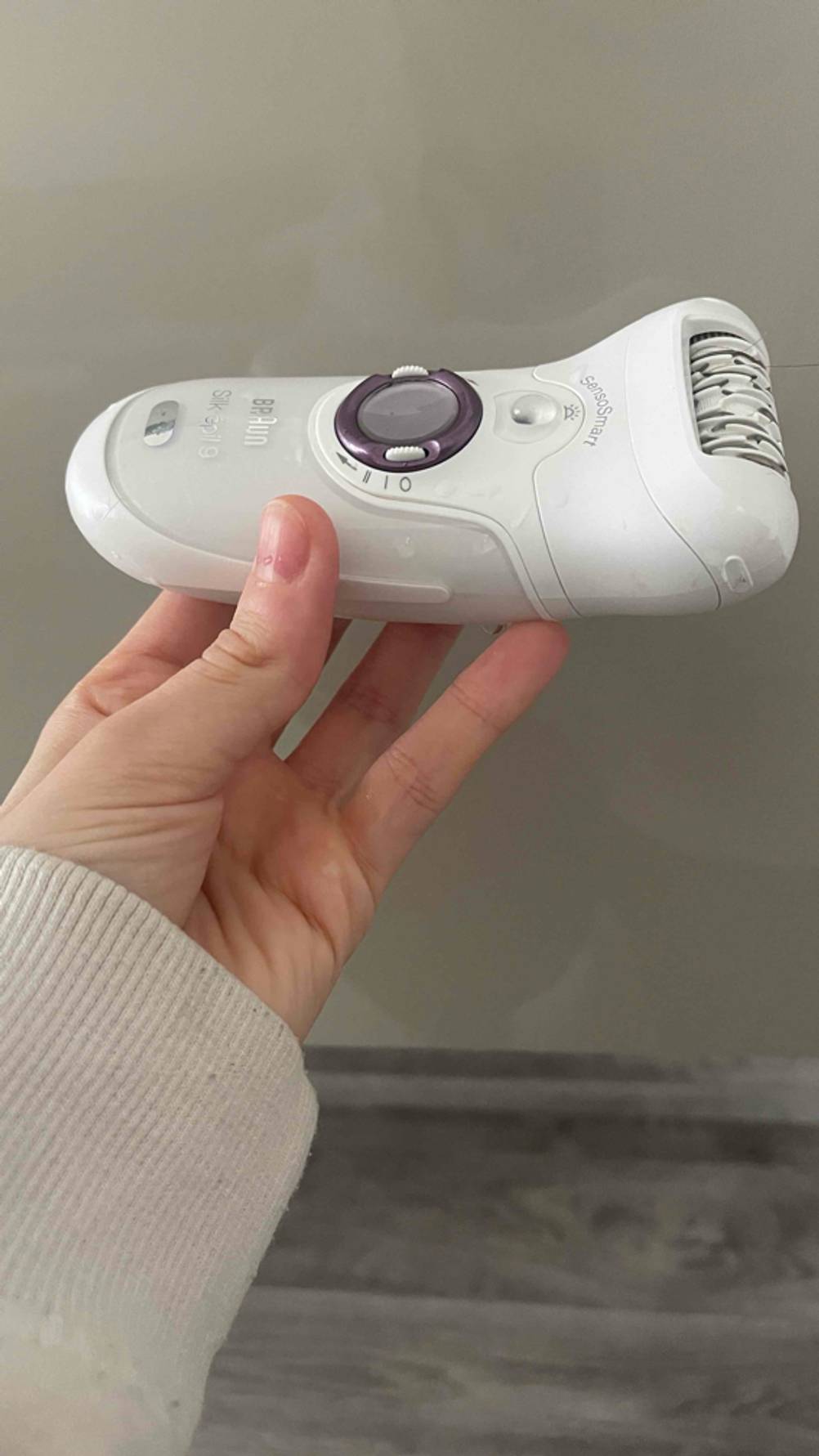 Eine Hand hält den Epilierer für den Haarentfernungs-Test.