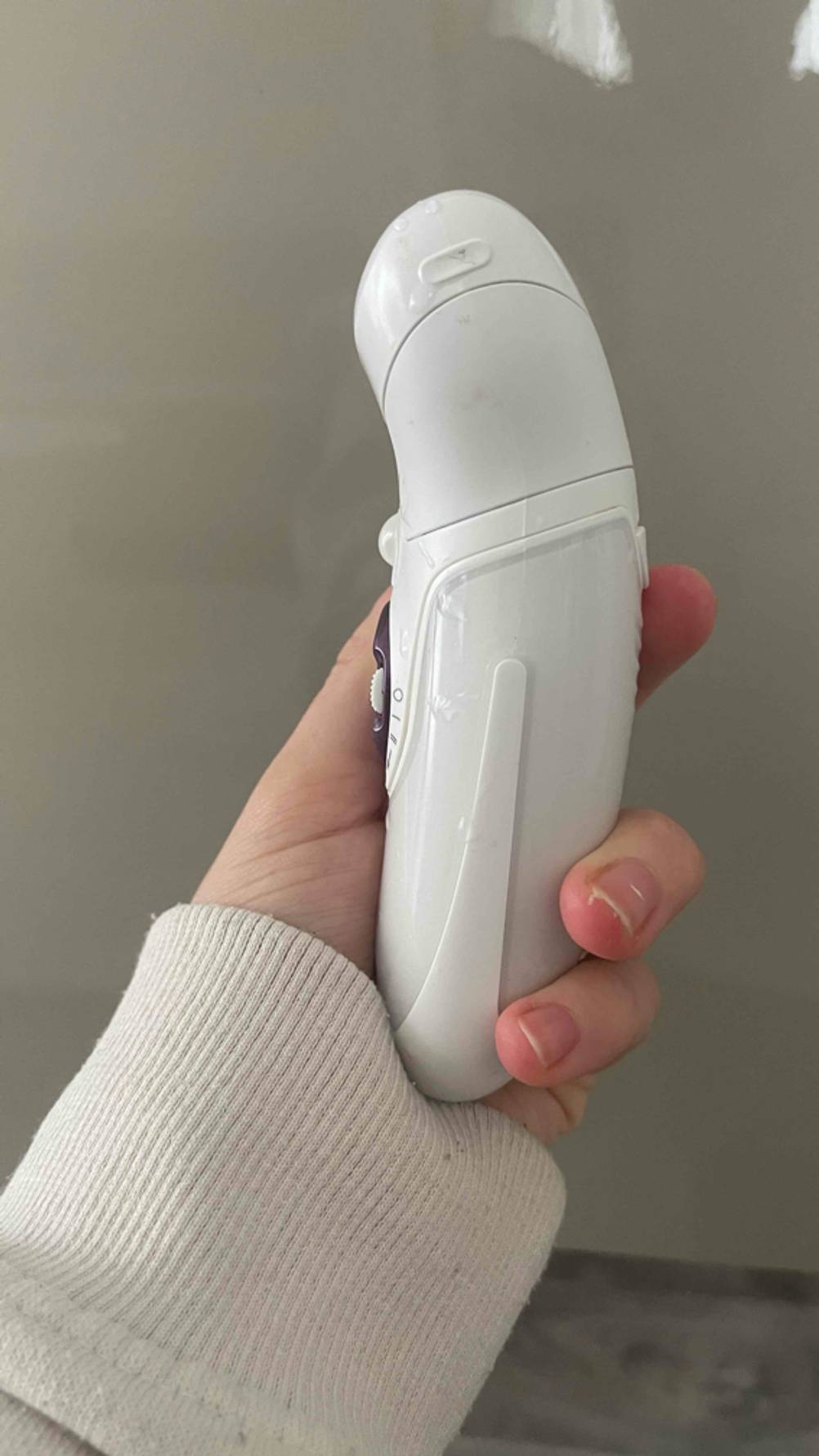 Haarentfernung im Test: Eine Hand hält einen Epilierer seitlich.