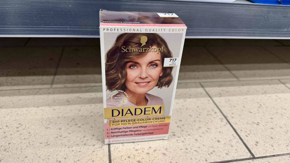 Haarfarbe hellbraun getestet: Eine Packung steht vor einem Regal auf dem Boden.