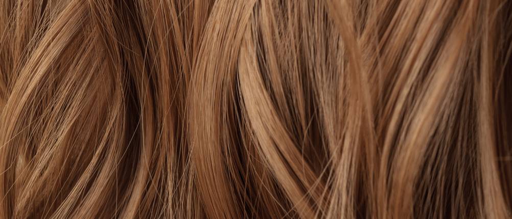 Haarfarbe-hellbraun-Test: Nahaufnahme von hellbraunem und leicht gewelltem Haar.