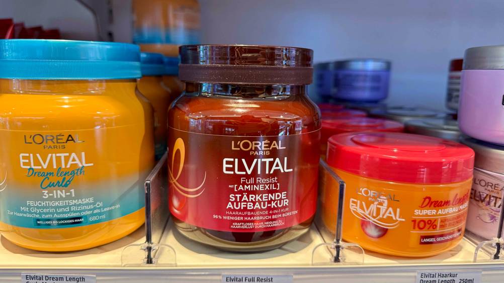 Eine getestete Haarkur ohne Ausspülen neben anderen Produkten in einem Verkaufsregal.