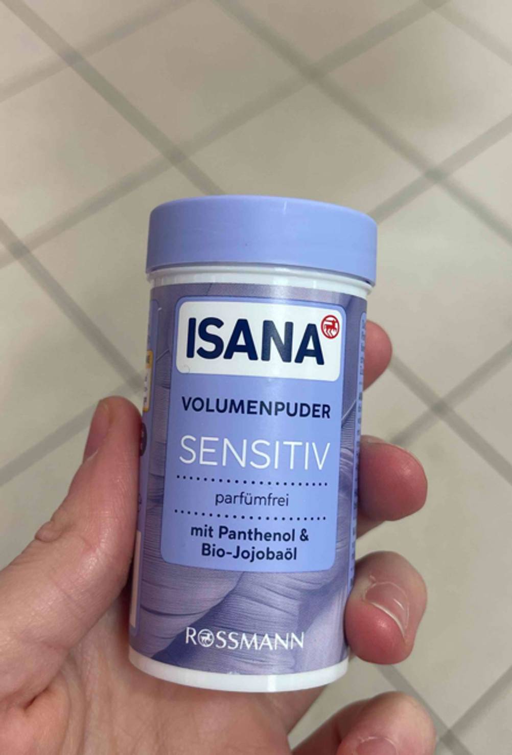 Das Haarpuder im Test befindet sich in der lilafarbenen 10-g-Dose, die von einer Hand gehalten wird.
