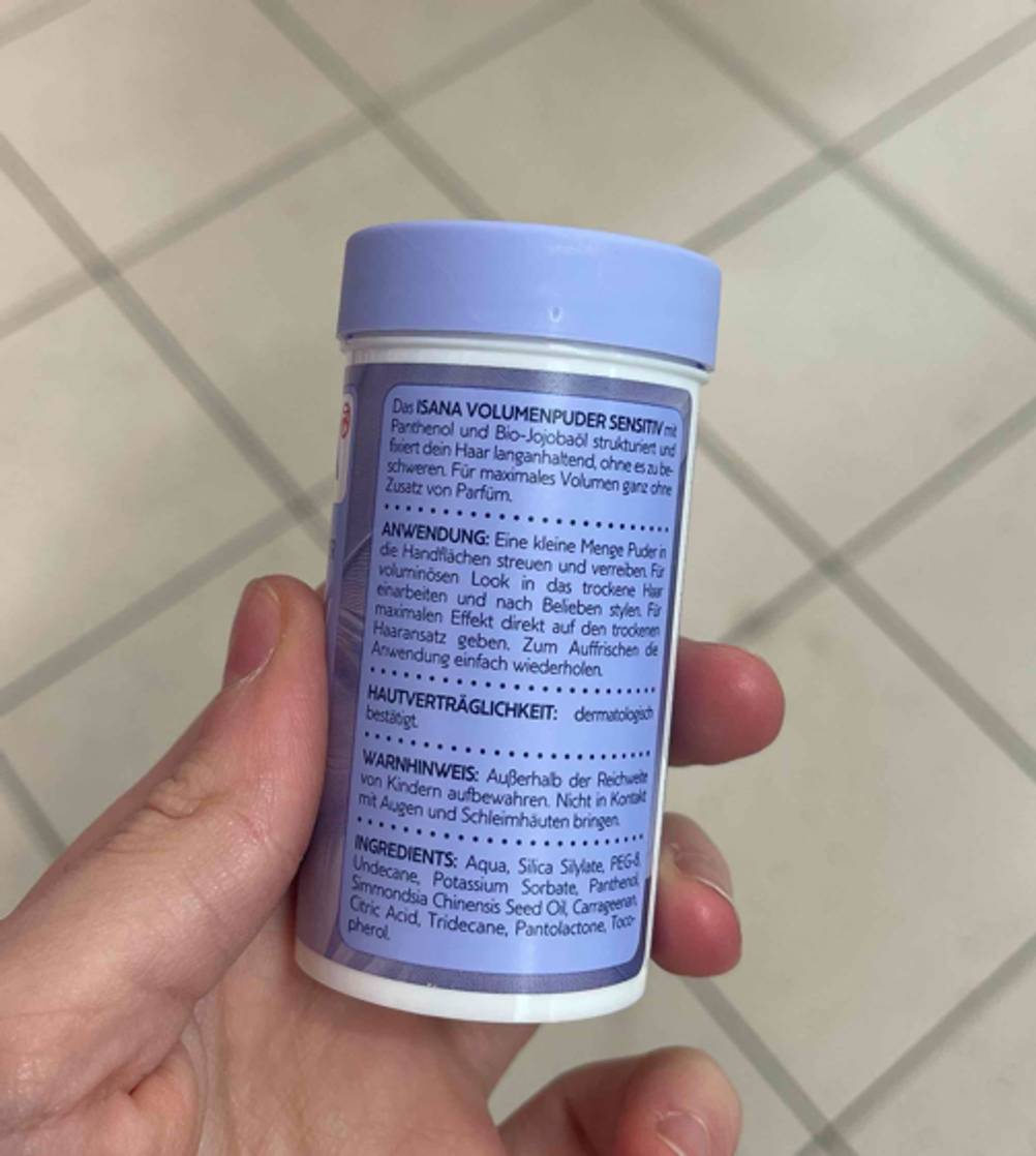 Getestet: Das Haarpuder in einer lilafarben Dose mit Schraubverschluss wird von einer Hand gehalten.