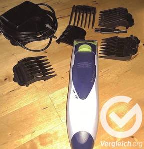 Ein getesteter Haarschneider mit den verschiedenen Aufsätzen liegt auf dem Boden.