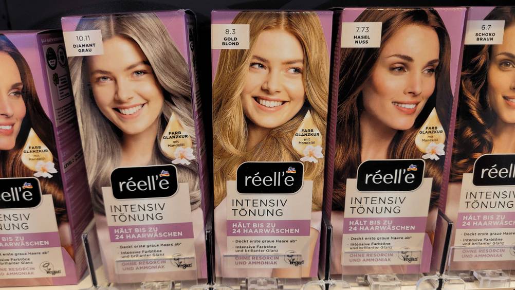 Mehrere Packungen der getesteten Haartönung blond in einem Verkaufsregal.