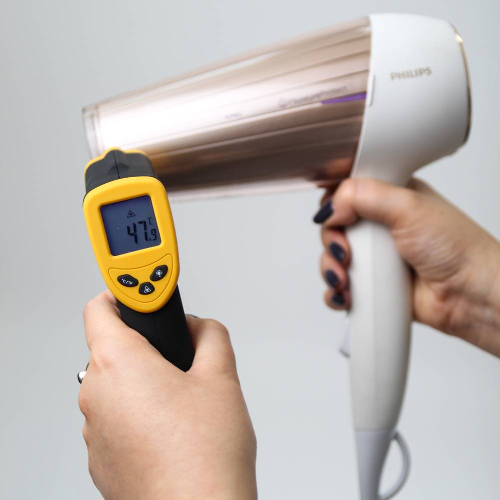 Ein weißer Philips Haartrockner im Test wird auf die Temperatur gemessen.