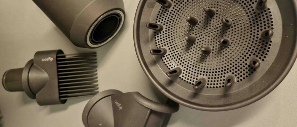 Das Zubehör eines getesteten Dyson Haartrockners liegt nebeneinander.