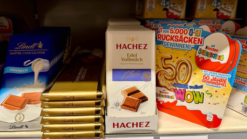 Getestet: Mehrere Tafeln Hachez-Schokolade in einem Regal neben anderen Produkten.
