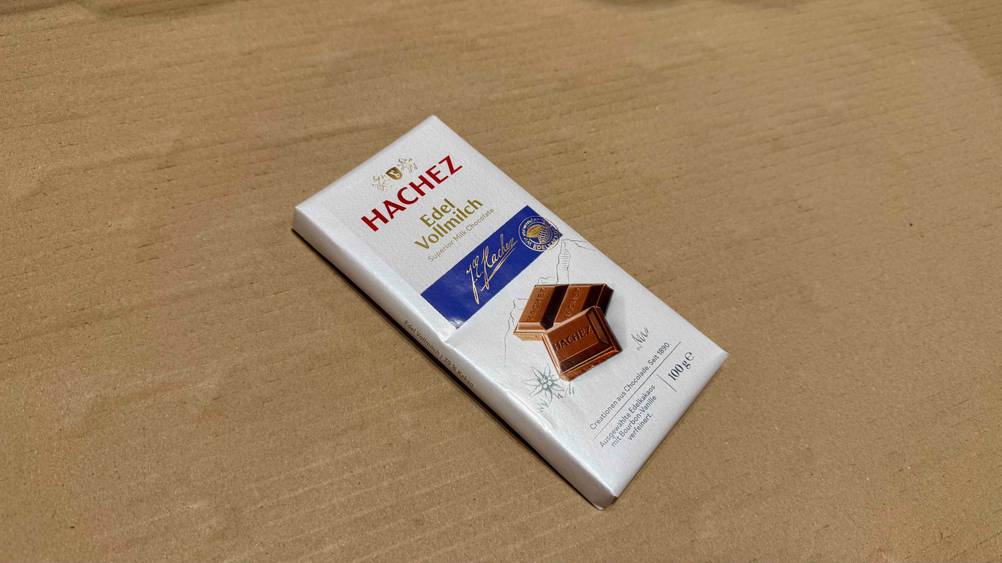 Auf einem Karton liegt eine Hachez-Schokolade im Test leicht schräg.