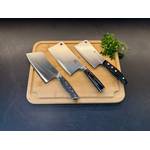 Drei Hackmesser liegen nebeneinander neben Petersilie auf einem Holzbrett