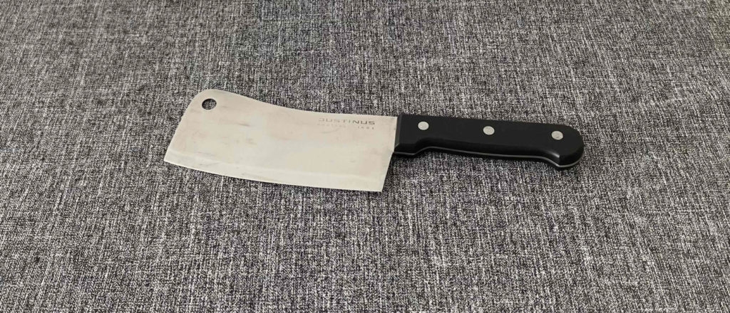 Das getestete Hackmesser liegt auf einer grauen Unterlage.