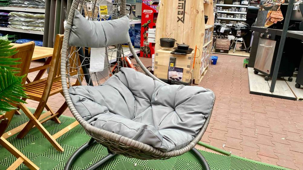 Ein getesteter Hängesessel (Rattan) von schräg seitlich in einer Verkaufsfläche.