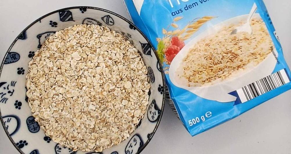 Haferflocken im Test: Nahaufnahme einer Packung die neben einer Schüssel mit Flocken liegt.