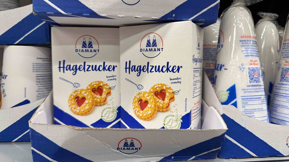 Mehrere Packungen des getesteten Hagelzuckers neben anderen Produkten in einem Verkaufsregal.