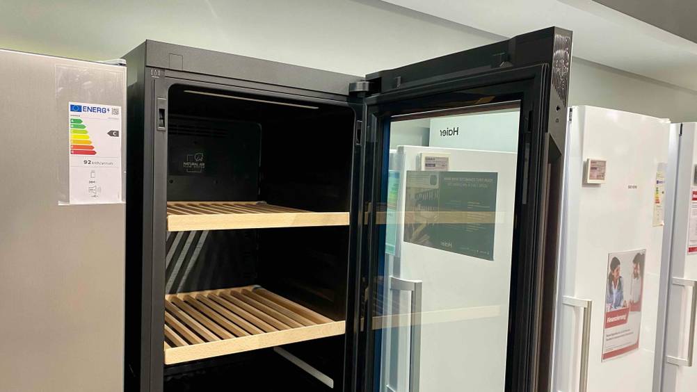 Weinkühlschrank-Test: Ein geöffneter Schrank mit Einlegeböden aus Holz in einer Ausstellung.