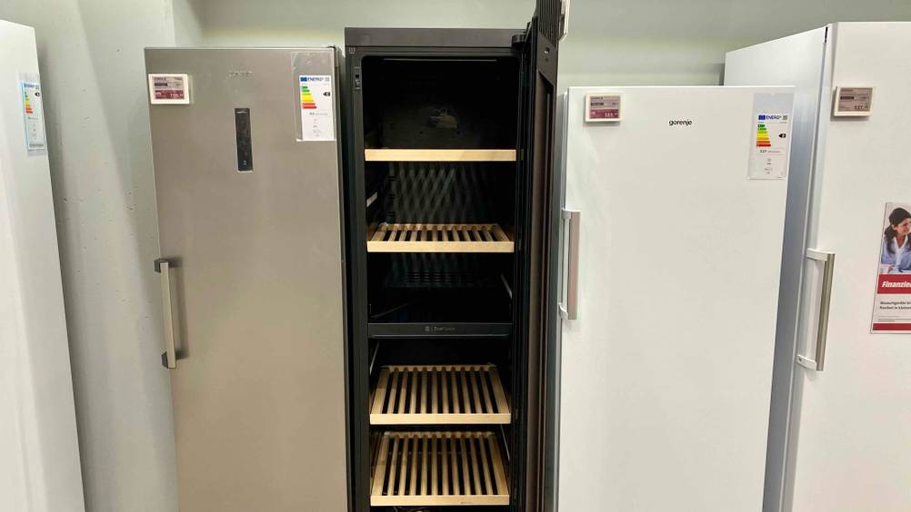 Weinkühlschrank getestet: Ein geöffneter Schrank mit hölzernen Einlegeböden, neben anderen Geräten