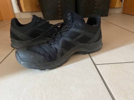 Ein Paar schwarze getestete Sicherheitsschuhe von Haix mit Schnürung steht auf einem Fliesenboden.