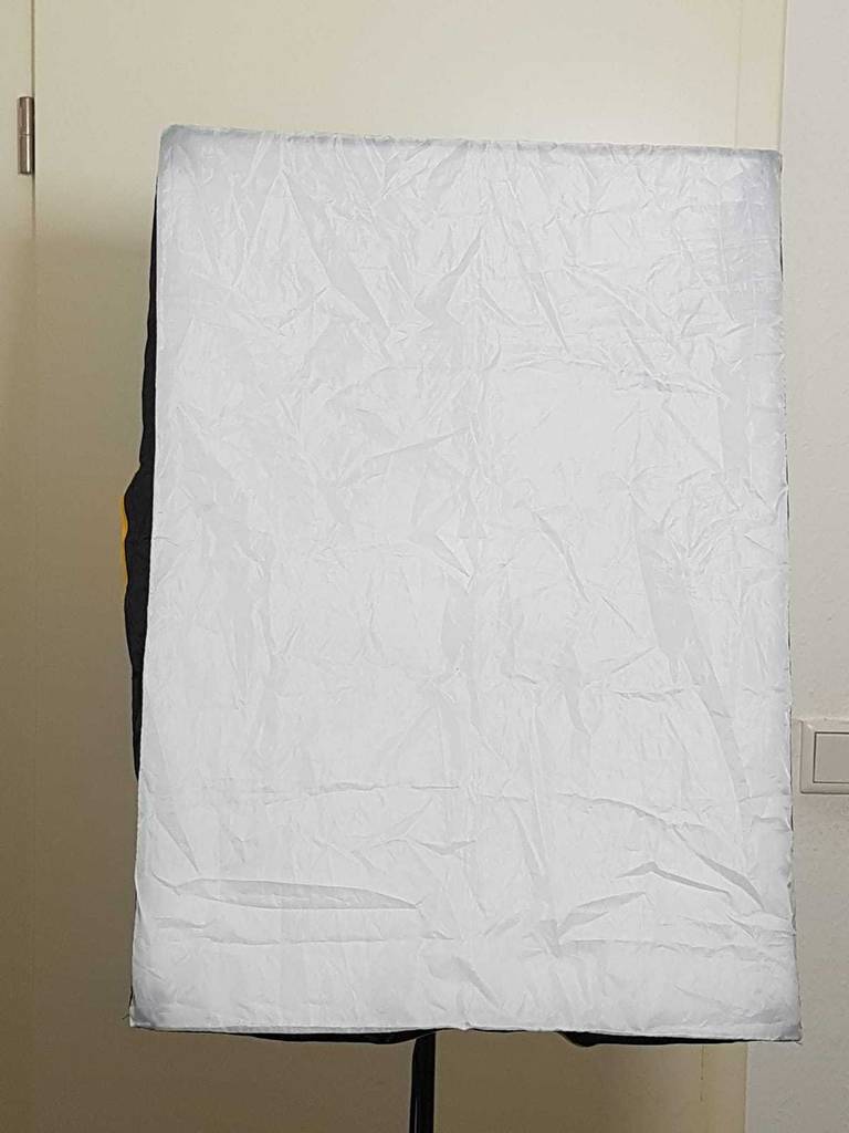 Detailansicht der weißen Stoff-Abdeckung einer getesteten Softbox vor weißer Wand.