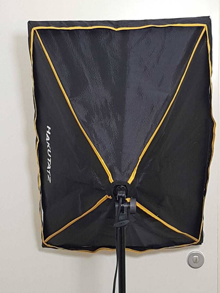 Softbox im Test: Ansicht von hinten eines schwarzen Schirms mit gelben Ziernähten, der auf einem schwarzen Gestell montiert ist.
