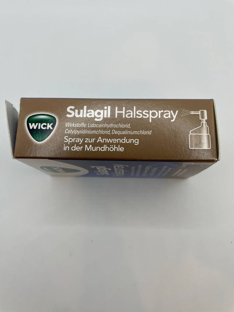 Auf dem Boden steht eine getestete Halsspray-Packung.