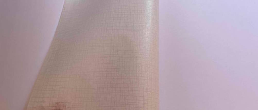 Fotoalbum getestet: Eine Hand blättert eine Schutzseite eines Albums um.
