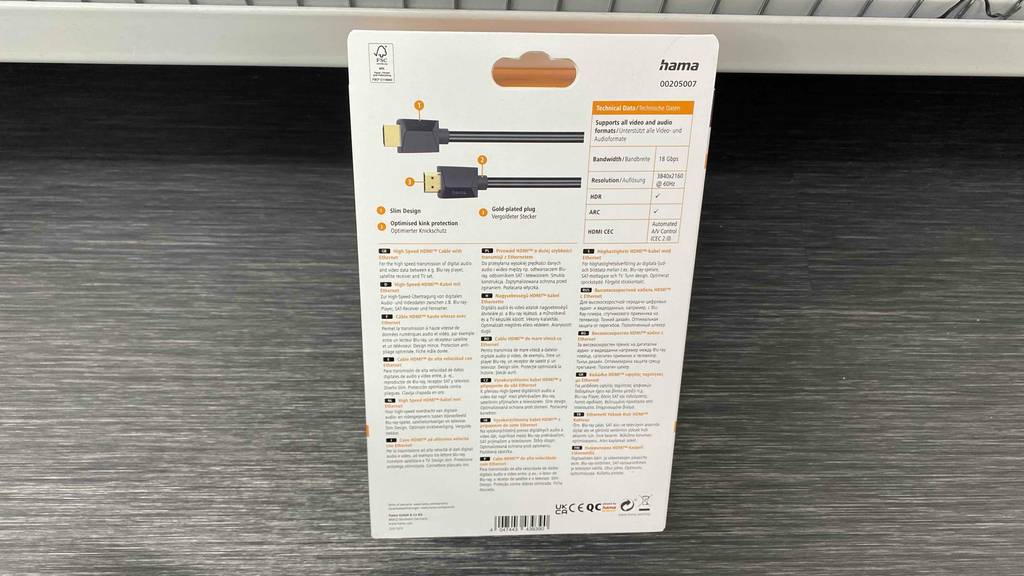Hama-HDMI-Kabel in 5 Meter Läange getestet: Eine weiße Verpackung steht sichtbar von hinten inklusive Produktinformationen an einen Verkaufsstand auf grauem Boden gelehnt.