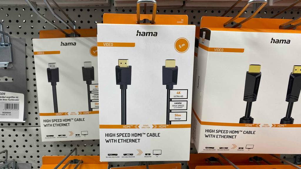 Mehrere weiße Verpackungen mit 5 Meter langen Hama-HDMI-Kabeln im Test hängen an einem Verkaufsstand.
