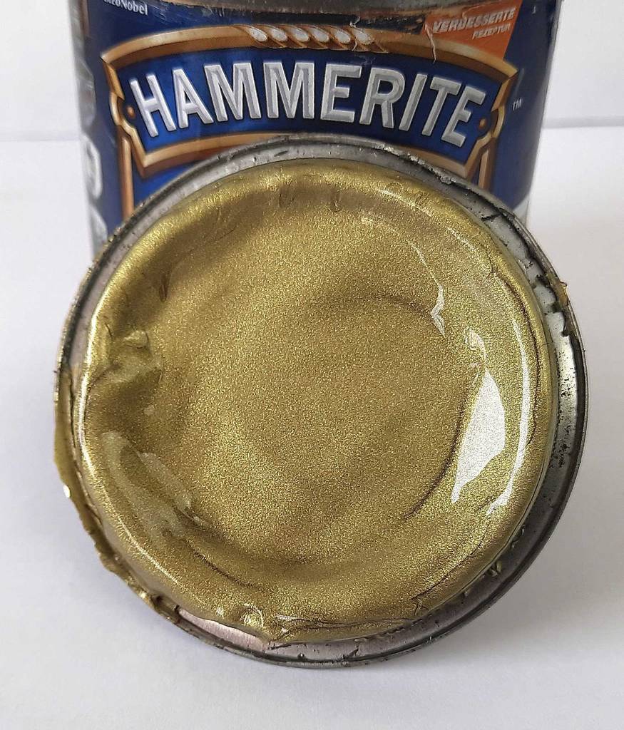 Im Test: Goldlack auf dem Deckel einer geöffneten Farbdose.