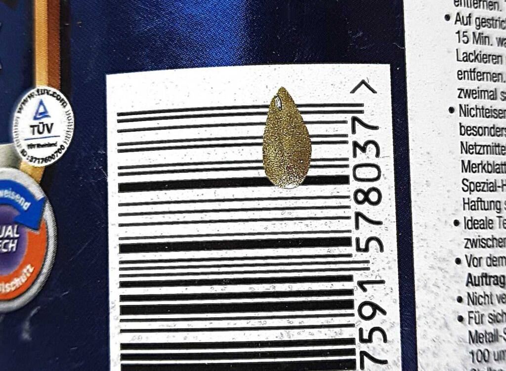 Ein Tropfen getesteter Goldlack befindet sich auf dem Barcode der Farbdose.