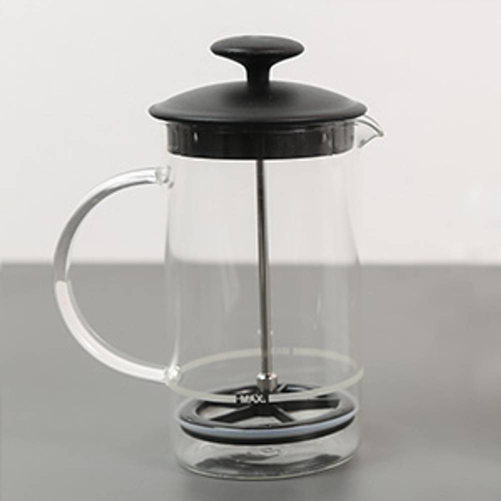 Hand-Milchaufschäumer getestet: Ein Hand-Milchaufschäumer aus Glas steht auf einem grauen Tisch.
