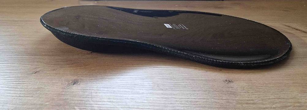 Rückseite einer getesteten Handgelenkauflage für Maus auf einer Holzfläche.