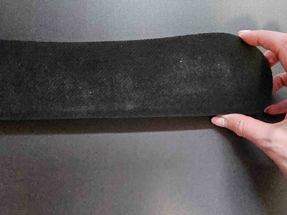 Nahaufnahme der Rückseite einer Tastatur-Handballenauflage im Test von einer Hand gehalten.
