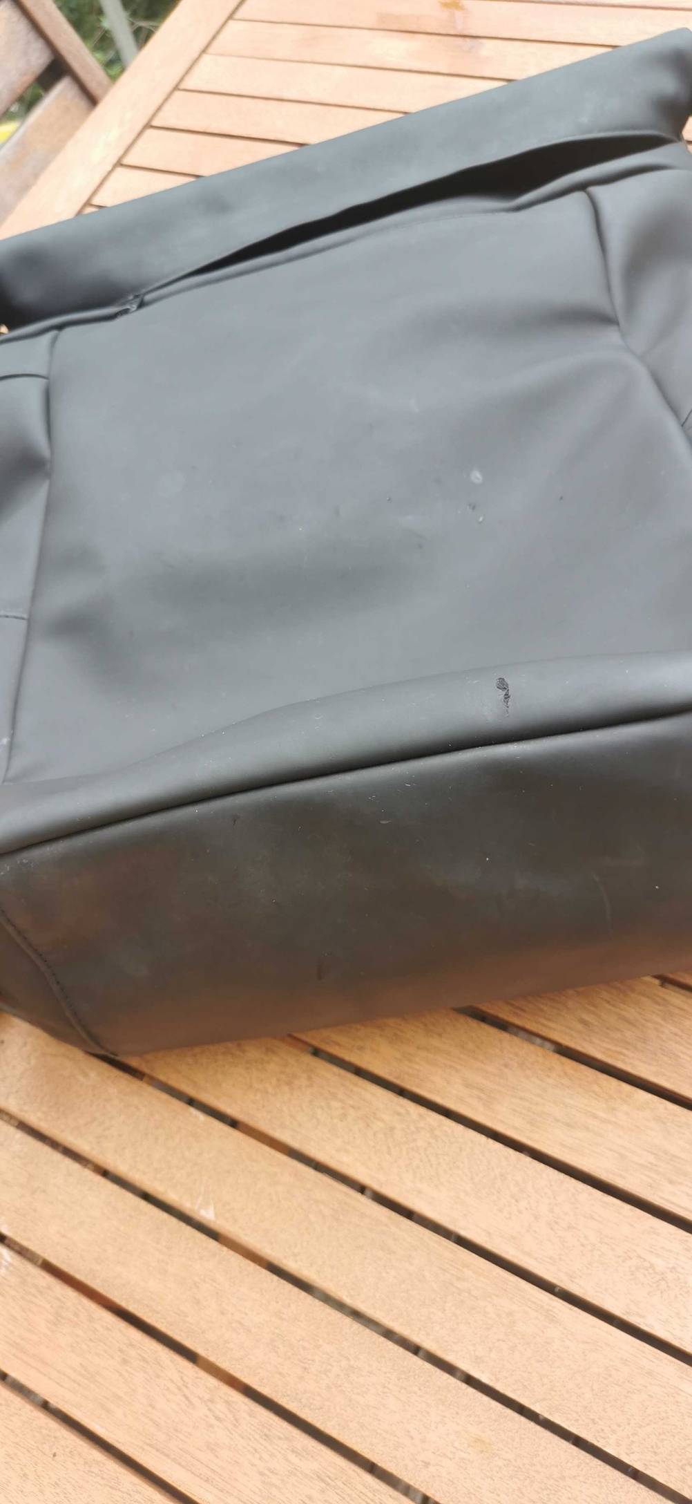 Nahaufnahme des Bodens eines Handgepäck-Rucksacks im Test auf einem Holztisch.