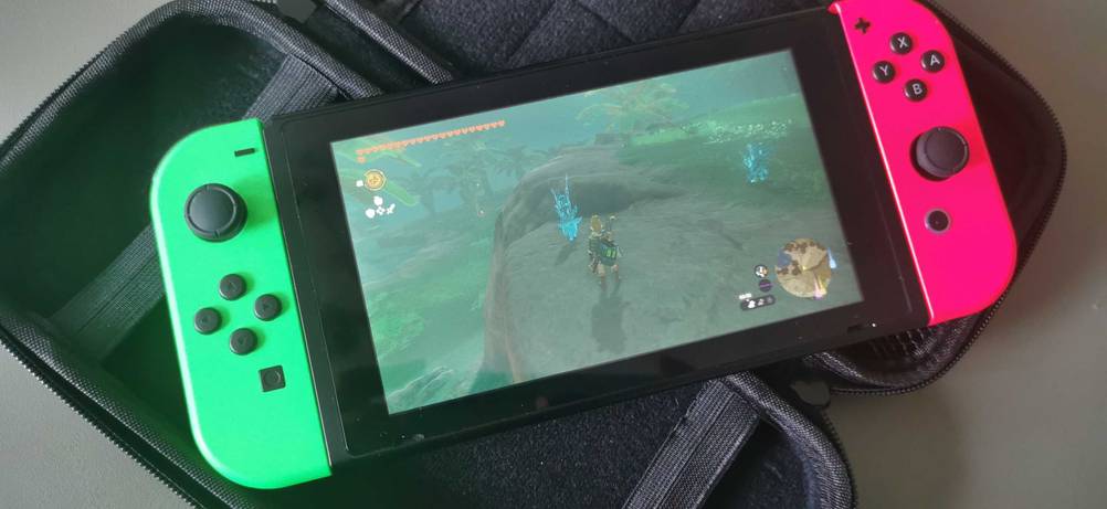 Eine getestete Handheld-Konsole mit einem laufenden Spiel im Dispaly auf einer Hülle.