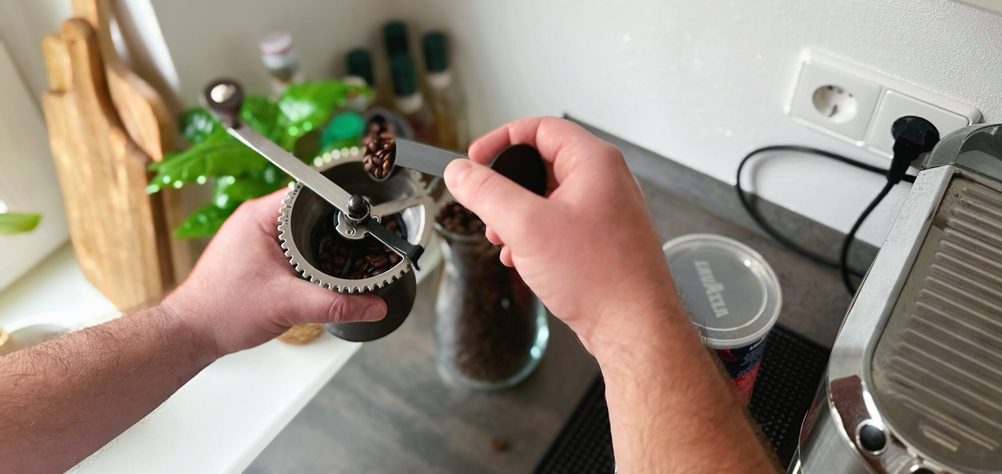 Handkaffeemühlen im Test: Die Kronos Handkaffeemühle wird mit Bohnen befüllt.