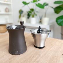 Handkaffeemühlen im Test: Eine auseinandergeschraubte Peugeot Kronos Handkaffeemühle steht auf einem Wohnzimmertisch.