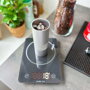 Handkaffeemühle von Waldwerk getestet: Nahaufnahme einer Kaffeemühle auf einer Waage die 18 g anzeigt.