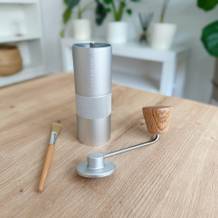 Handkaffeemühlen im Test: der volle Lieferumfang der Kaffeemühle von Waldwerk liegt auf einem Wohnzimmertisch.