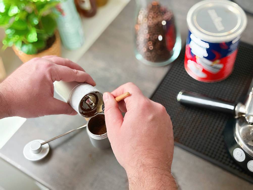 Handkaffeemühle im Test: Die Kaffeemühle von Waldwerk wird mit einem Pinsel gereinigt.