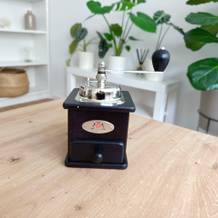 Handkaffeemühlen im Test: Eine Kaffeemühle in Retro-Optik steht auf einem Wohnzimmertisch.