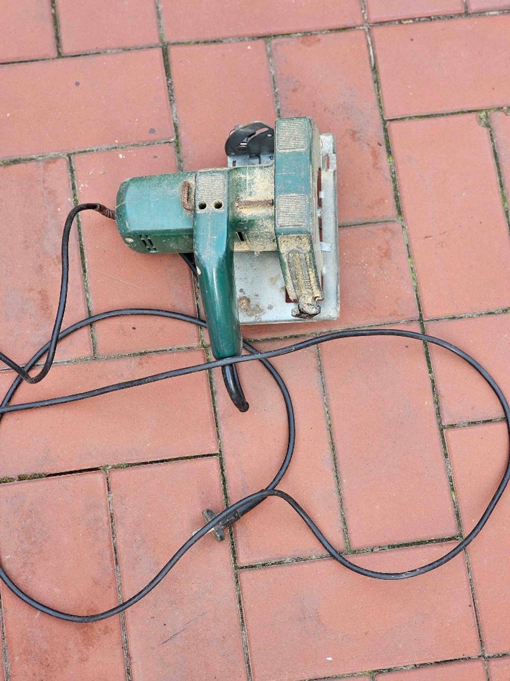 Getestet: Eine Handkreissäge mit Führungsschiene von oben inklusive Stormkabel auf einem Steinboden.