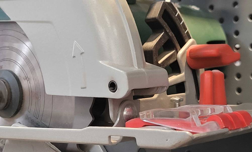 Handkreissäge mit Führungsschiene getestet: Nahaufnahme des Pfeils auf der Schutzhaube.