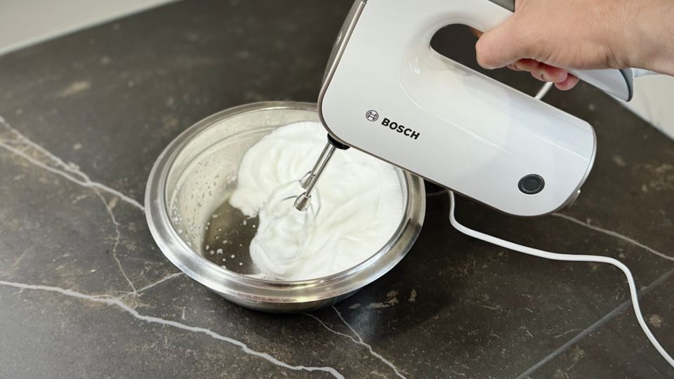 Handmixer im Test: Mit dem Bosch-Styline-Handmixer wird Eischnee in einer Metall-Schüssel aufgeschlagen.