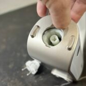 Handmixer im Test: Die Abdeckung des Stabmixer-Anschlusses auf der Rückseite des Handmixers wird geöffnet.