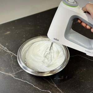 Handmixer-Test: Mit dem Braun-Handmixer wird in einer Metallschüssel Eischnee aufgeschlagen.
