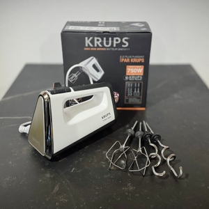 Handmixer getestet: Der Krups 3 Mix 9000 Handmixer getestet: Die Verpackung eines Krups 3 Mix 9000 steht zusammen mit dem Zubehör und der Verpackung auf einer Arbeitsfläche.